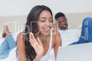 Relaxed woman using laptop on bed