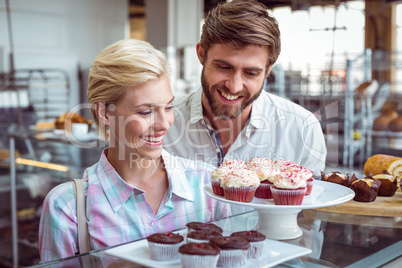 Cute couple on a date looking at cakes