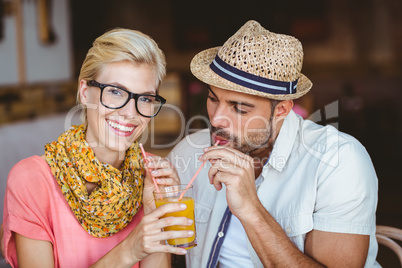 Cute couple on a date sharing an orange juice