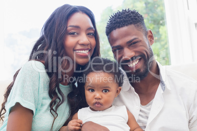 Happy parents with baby girl on couch