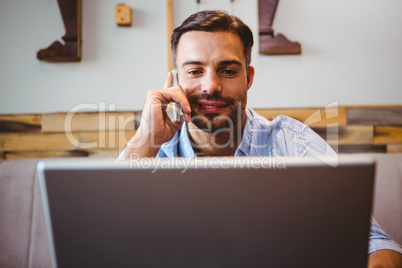 Smiling businessman using his laptop