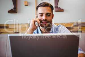 Smiling businessman using his laptop
