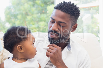 Happy father with baby girl on couch