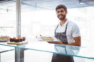 Smiling worker posing behind the counter