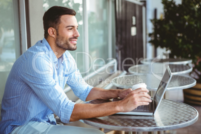 Smiling businessman using his laptop