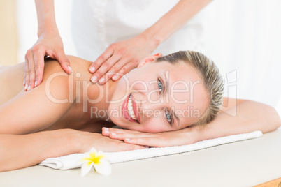 Pretty blonde enjoying a massage smiling at camera