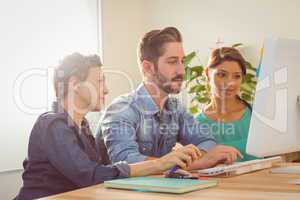 Colleagues using laptop at office