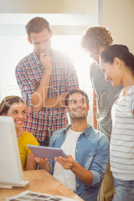 Creative business team gathered around a tablet