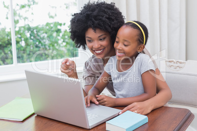 Happy mother and daughter using the laptop