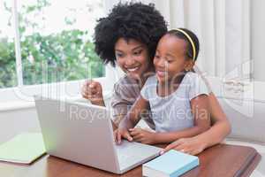 Happy mother and daughter using the laptop