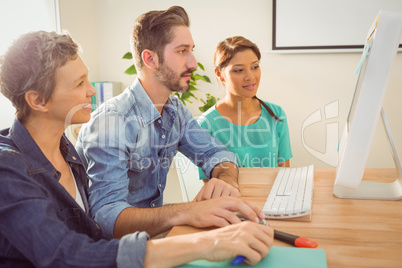 Colleagues using laptop at office