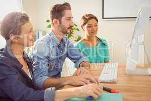 Colleagues using laptop at office