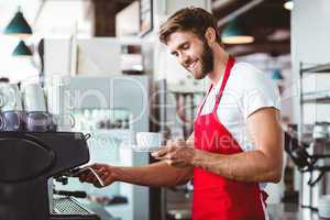 Handsome barista preparing a cup of coffee