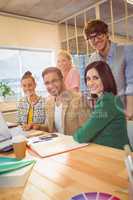 Happy colleagues using laptop in office