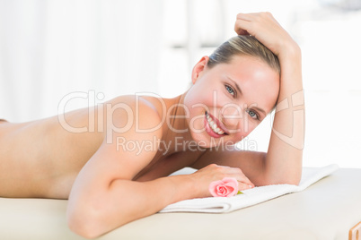 Peaceful blonde lying on towel smiling at camera