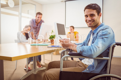 Creative businessman in wheelchair holding a phone