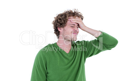 Anxious casual man standing with hand on forehead