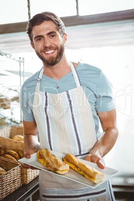 happy worker holding sandwiches