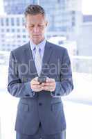 Businessman texting with his smartphone