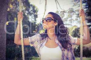 Pretty brunette swinging in park