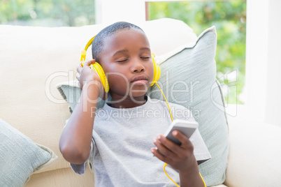 Little boy listening to music on the couch