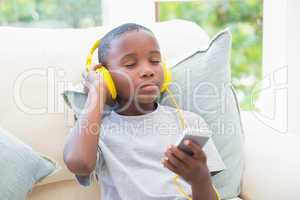 Little boy listening to music on the couch