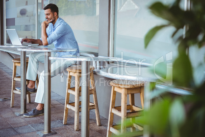 Thoughtful businessman using his laptop