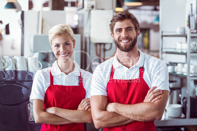 Two baristas smiling at the camera