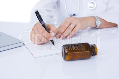 Doctor writing on a notepad