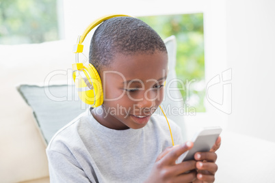 Little boy listening to music on the couch