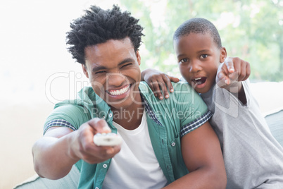 Father and son watching tv together on the couch