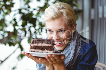 Smiling blonde looking a chocolate cake