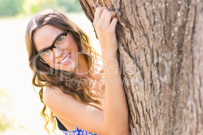 Pretty brunette hugging tree