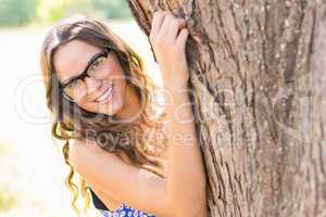 Pretty brunette hugging tree