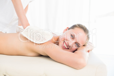 Peaceful brunette enjoying an exfoliating back massage