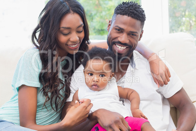 Happy couple with their baby girl on couch