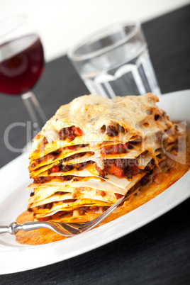 Nahaufnahme einer Lasagne mit Rotwein