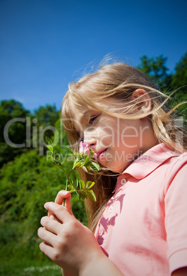 child smelling blossom