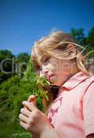 child smelling blossom