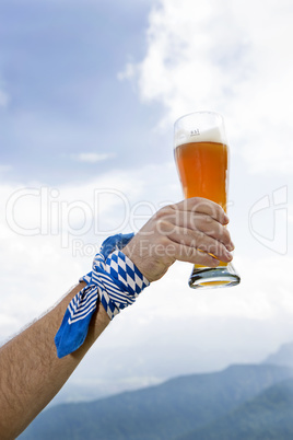Bavarain man holding wheat beer glass in the air