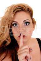 Woman holding finger on mouth.