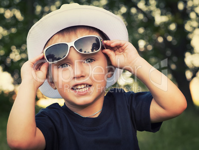 Portrait of a cheerful little boy in sunglasses