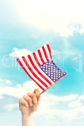 Composite image of hand waving american flag