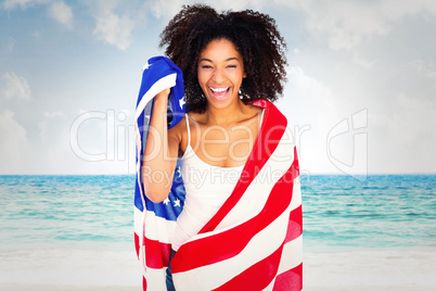 Composite image of pretty girl wrapped in american flag smiling