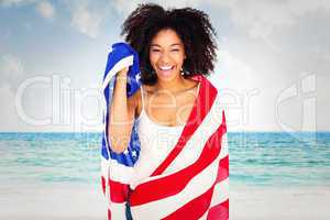 Composite image of pretty girl wrapped in american flag smiling