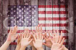 Composite image of people raising hands in the air