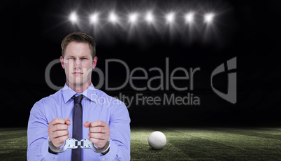 Composite image of handsome businessman wearing handcuffs