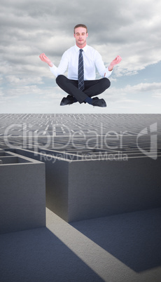 Composite image of businessman meditating in lotus pose