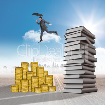 Composite image of businessman jumping holding an umbrella