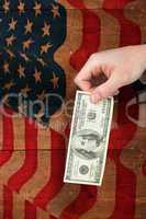 Composite image of hand holding hundred dollar bill